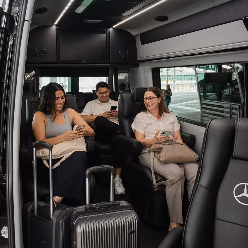 Passengers loading luggage while boarding an Charlotte group shuttle