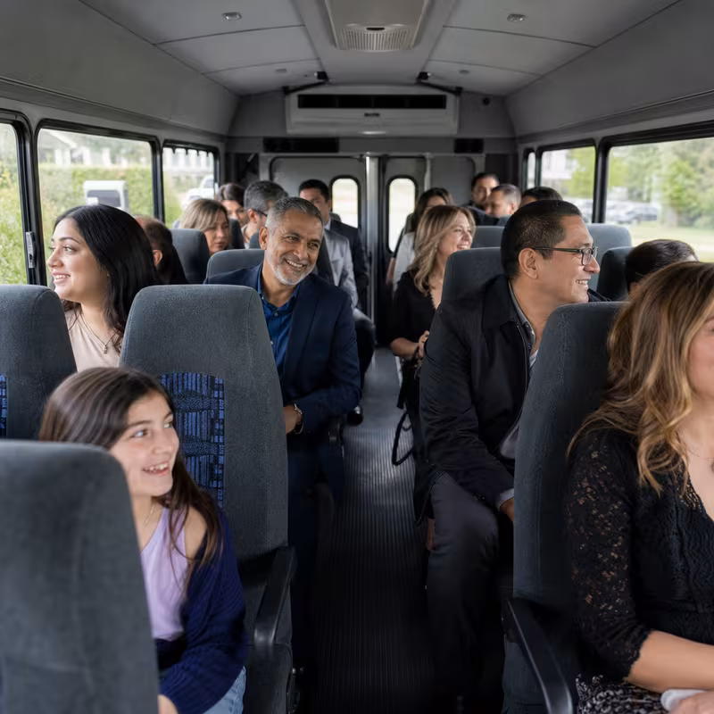 Group boarding a white charter bus for Private Event Transportation transportation in Charlotte