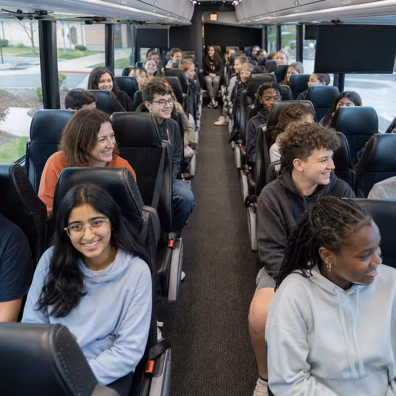 Group boarding a white charter bus for School Transportation transportation in Charlotte