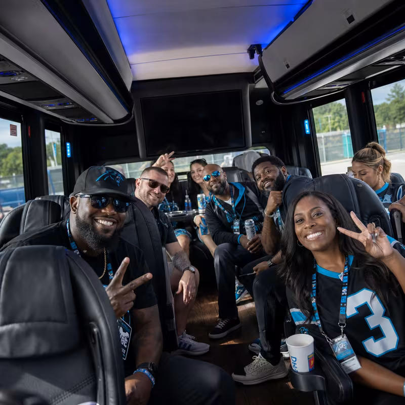 Group boarding a white charter bus for Sporting Event Transportation transportation in Charlotte